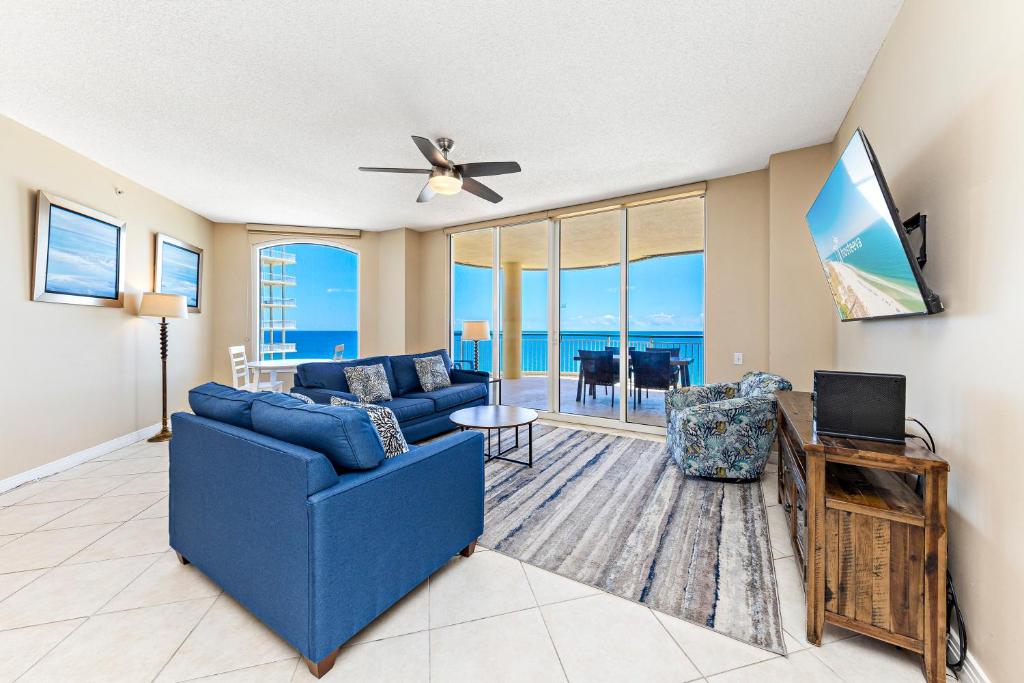 a living room with a blue couch and a tv at Beach Colony E10B in Pensacola