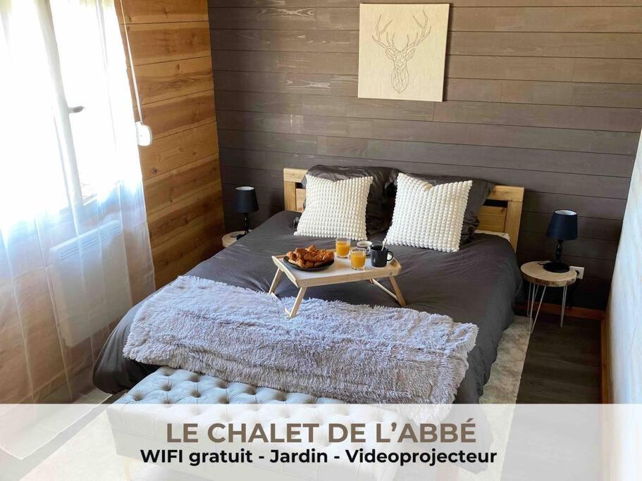 a bedroom with a bed with a table on it at Le Chalet de l'Abbé : magnifique maison chaleureuse in Cambrai