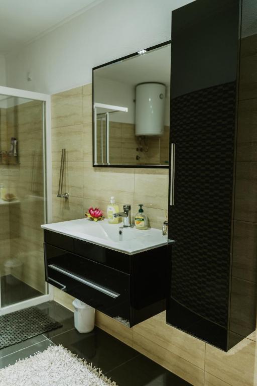 a bathroom with a sink and a mirror at Apartman Stil in Bugojno