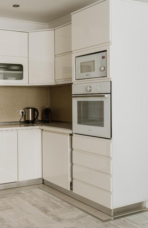 a white kitchen with white cabinets and appliances at Apartman Stil in Bugojno