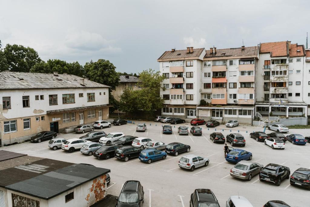 a parking lot with cars parked in front of buildings at Apartman Stil in Bugojno