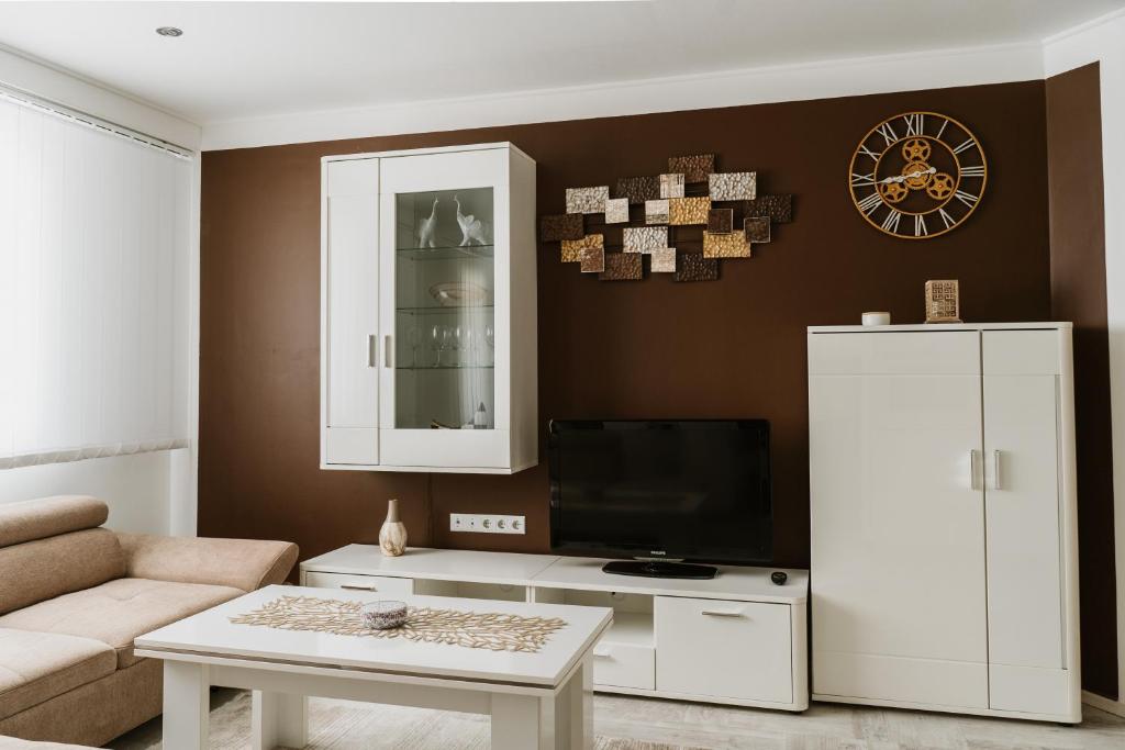 a living room with a tv and a white cabinet at Apartman Stil in Bugojno