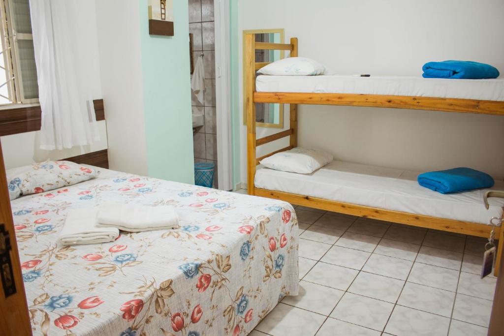 a room with two bunk beds and a tiled floor at Pousada Monsenhor in Cachoeira Paulista