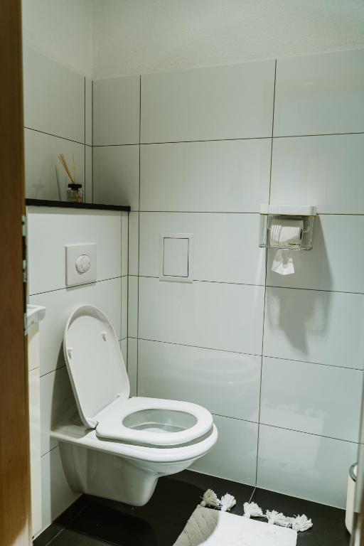 a white bathroom with a toilet and a shower at Apartman Stil in Bugojno