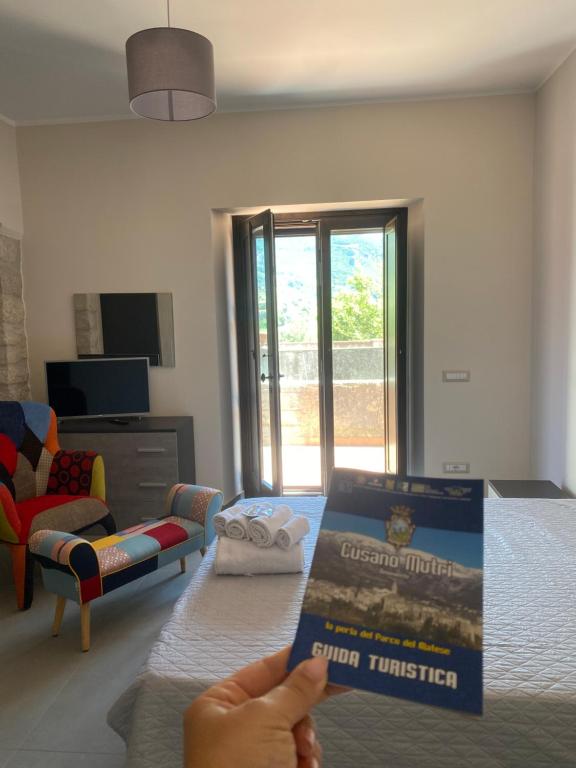 een persoon met een pizzadoos in een woonkamer bij B&B La Terrazza su Monte Mutria in Cusano Mutri