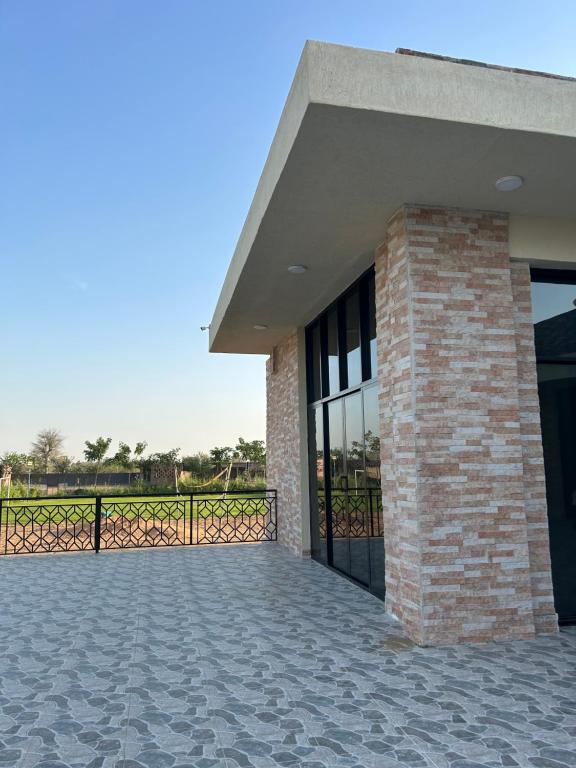 a brick building with a gate and a patio at The Mountain Farm in Ras al Khaimah