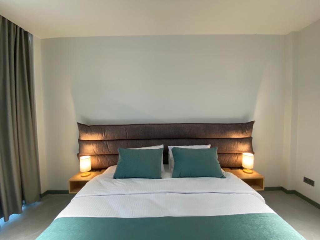 a bedroom with a large bed with two green pillows at H2O in Ureki