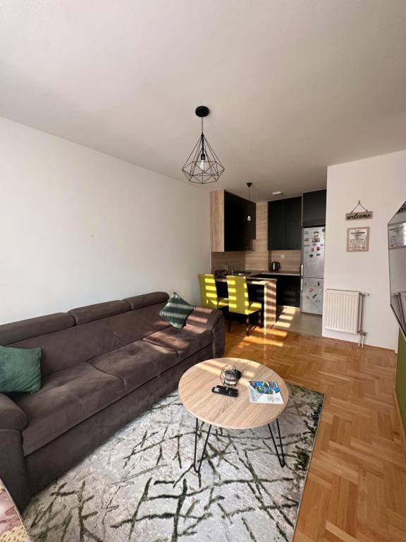 a living room with a brown couch and a table at Apartman Stevanovic BN in Bijeljina