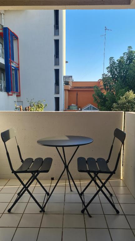 un tavolo e 2 sedie seduti su un balcone di Casa Mistral a Bari