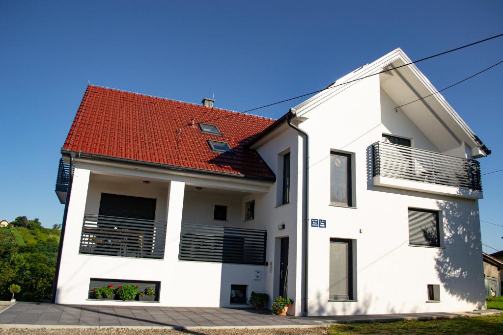 a white house with a red roof at Kraljeva hiža - Apartmani i sobe Kralj in Sveti Martin na Muri