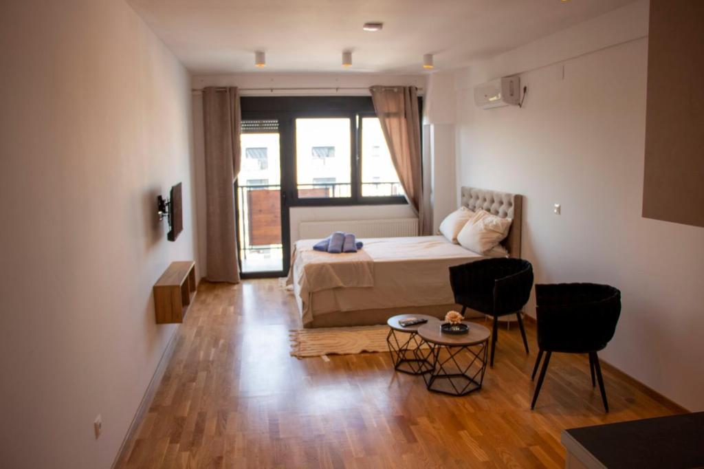 1 dormitorio con 1 cama, mesa y sillas en Harmony Studio Apartment, en Jagodina