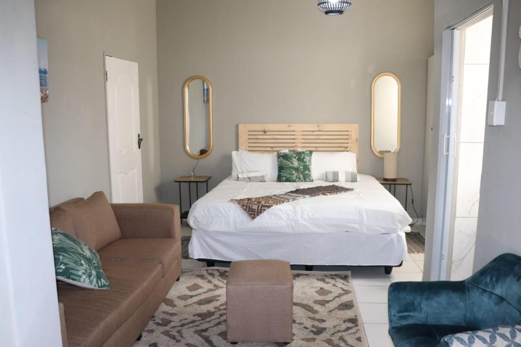 een slaapkamer met een bed en een bank bij Unitrainview guest house in Pretoria
