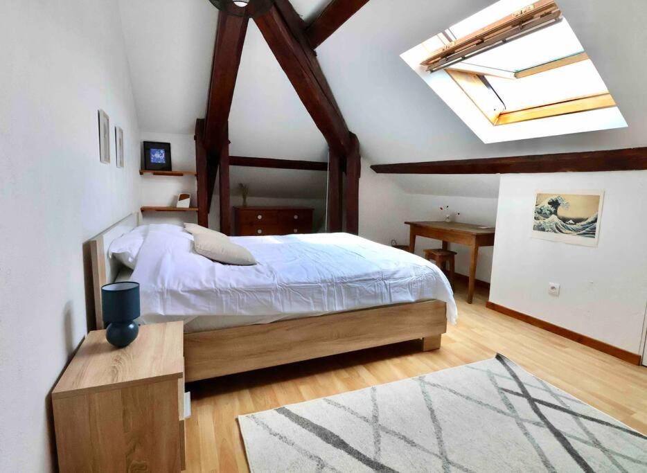 - une chambre avec un grand lit et une lucarne dans l'établissement Les Hauts du Château, à Chambéry