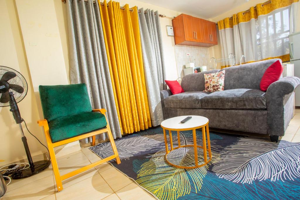 a living room with a couch and a chair at Tom Mboya Estate - Fast WI-FI, Netflix and Parking 1Br Apartment in Kisumu Town in Kisumu