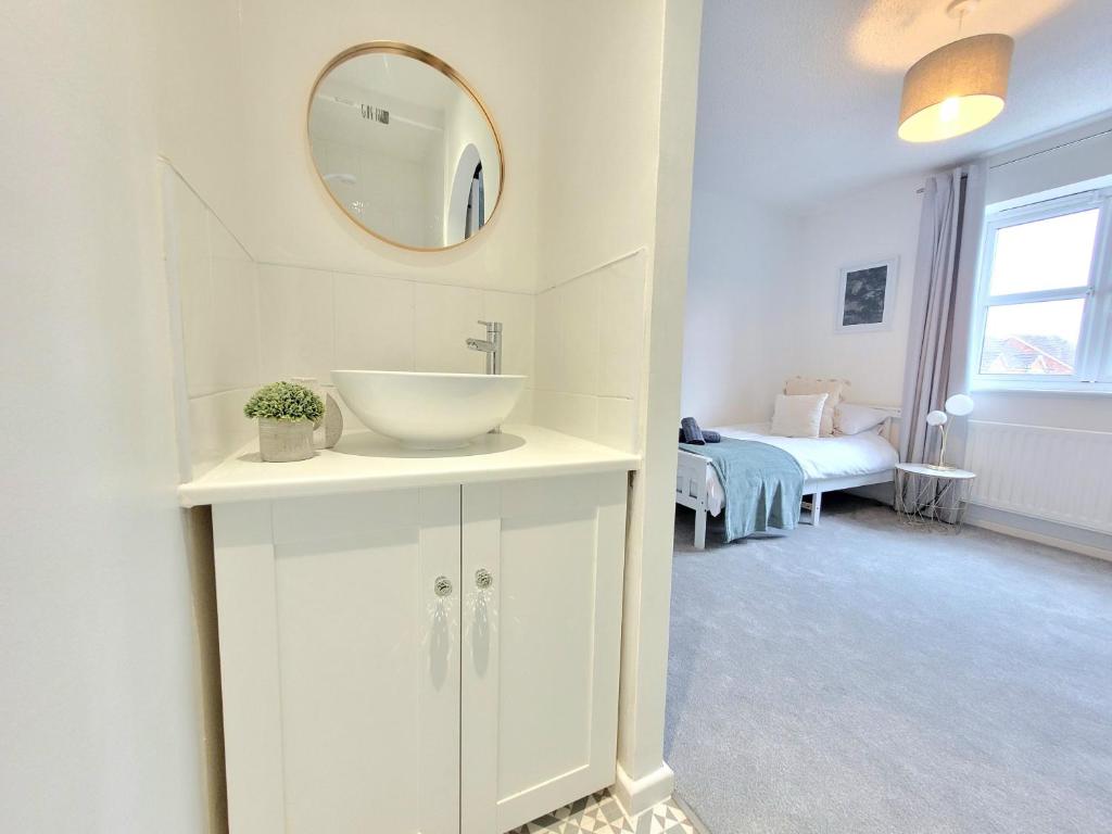 uma casa de banho branca com um lavatório e um espelho em Stay @ Enville Close, Birmingham Airport & NEC em Marston Green