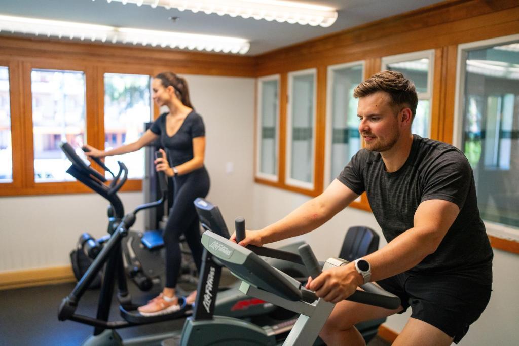 a man and woman riding on exercise bikes in a gym at Whistler Village Inn & Suites in Whistler