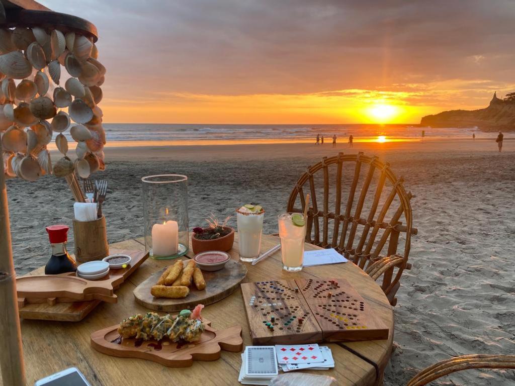 a table on the beach with food and candles at Casa Caracol in Montañita