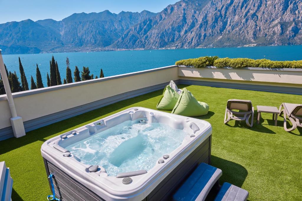 a hot tub on a balcony with a view of the water at Wind Hotel in Malcesine