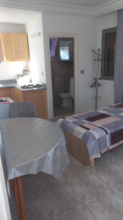 1 dormitorio con 1 cama y cocina con fregadero en Residence djerba 1 en Houmt El Souk