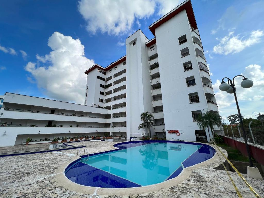 un bâtiment avec une piscine en face d'un bâtiment dans l'établissement Magico Apartamento con Piscina 1 Habitación PR65, à Montería