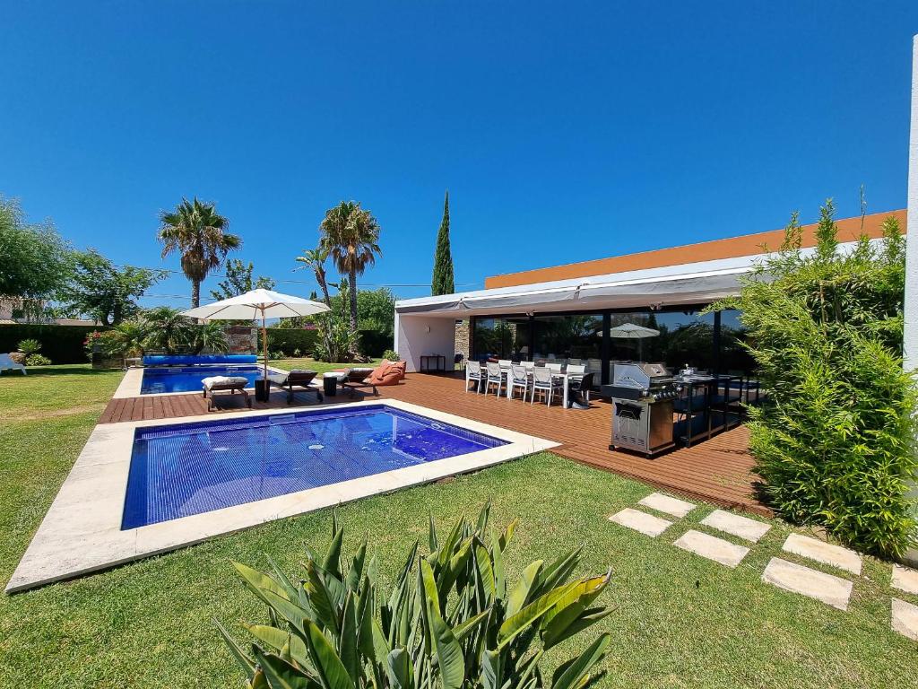 een achtertuin met een zwembad en een huis bij Villa Monte Canelas in Portimão