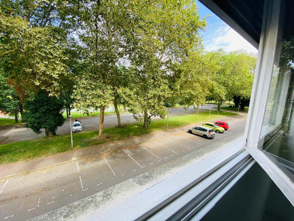 een raam met uitzicht op een straat met auto's bij Chambre Madoumier in Limoges