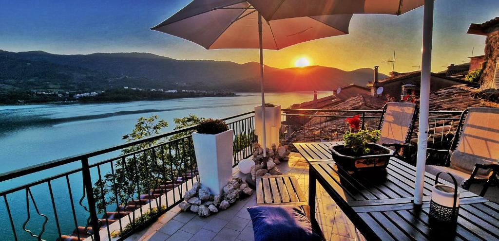 balkon z parasolem i widokiem na rzekę w obiekcie La terrazza sul lago Turano w mieście Vermiglio