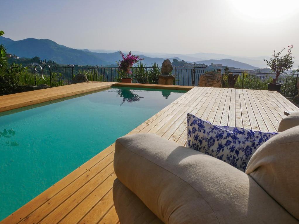 una piscina con divano su una terrazza in legno di Dimora d'Arte Mariano Pietrini a Barcellona Pozzo di Gotto
