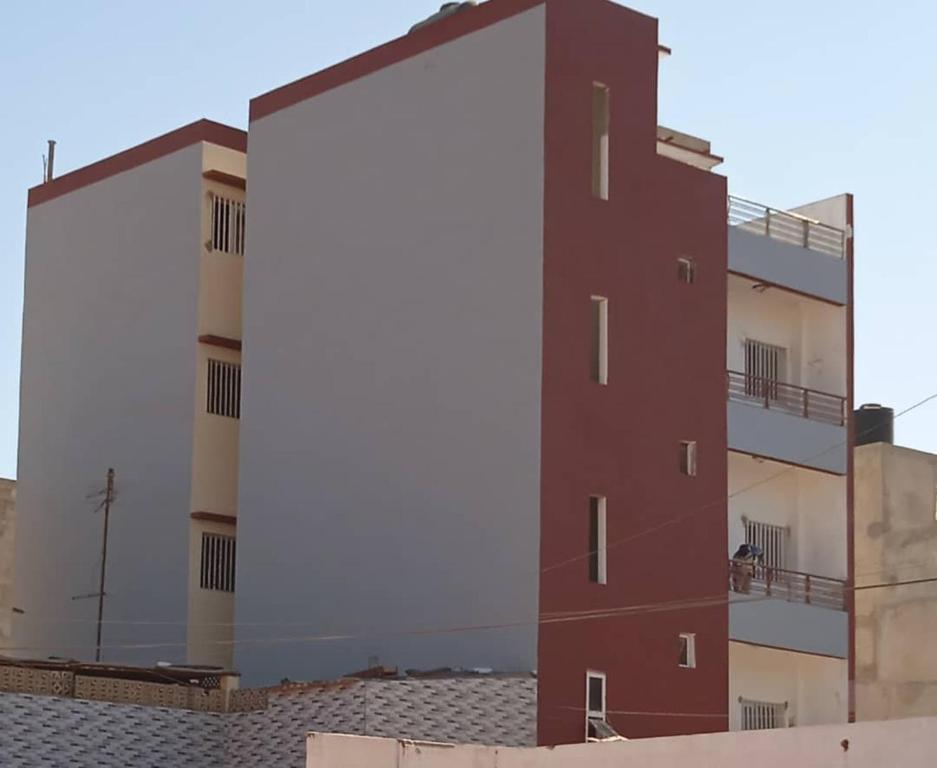 a tall red building with balconies on top of a building at CHEZ NDAYE AMY in Dakar