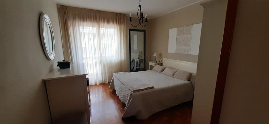 um pequeno quarto com uma cama e uma janela em Sella em Arriondas