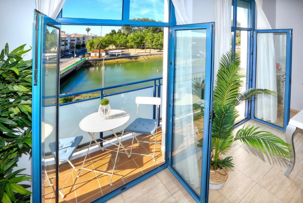 een balkon met een tafel en uitzicht op het water bij Apartamento GUADIANA RÍA - Centro in Ayamonte