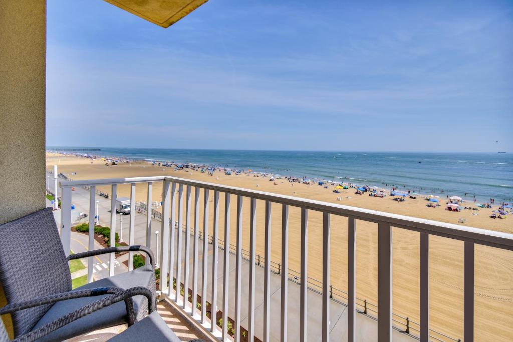 a balcony view of a beach with a chair and the ocean at Inviting Virginia Beach Condo with Community Pool in Virginia Beach