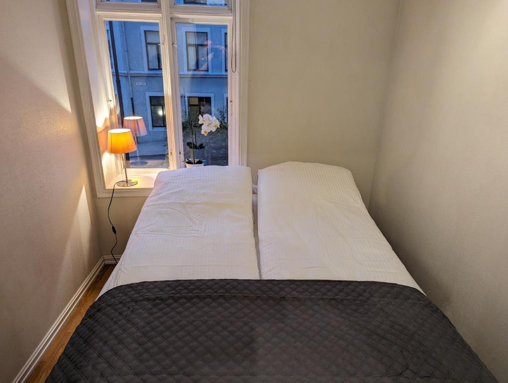 a bed in a small room with a window at Apartment in Ålesund city center (Storgata) in Ålesund