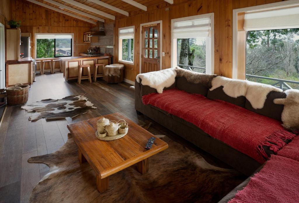 uma sala de estar com um sofá e uma mesa em Cabaña puerto varas, a orillas del Lago LLanquihue em Puerto Varas