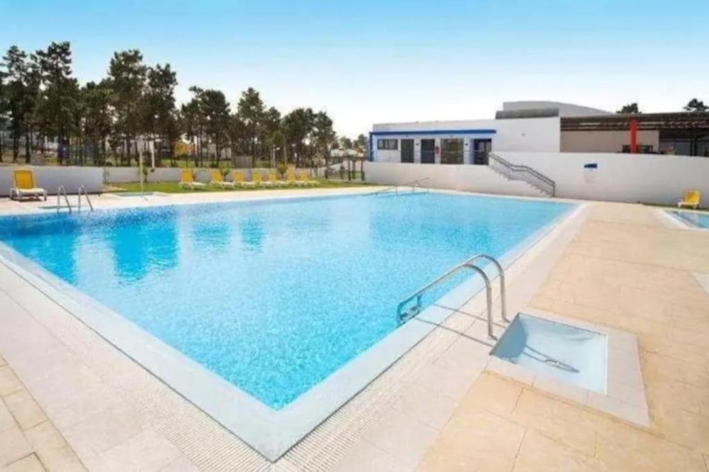 duży basen z niebieską wodą w obiekcie Borboletas Loft w mieście Quinta do Anjo