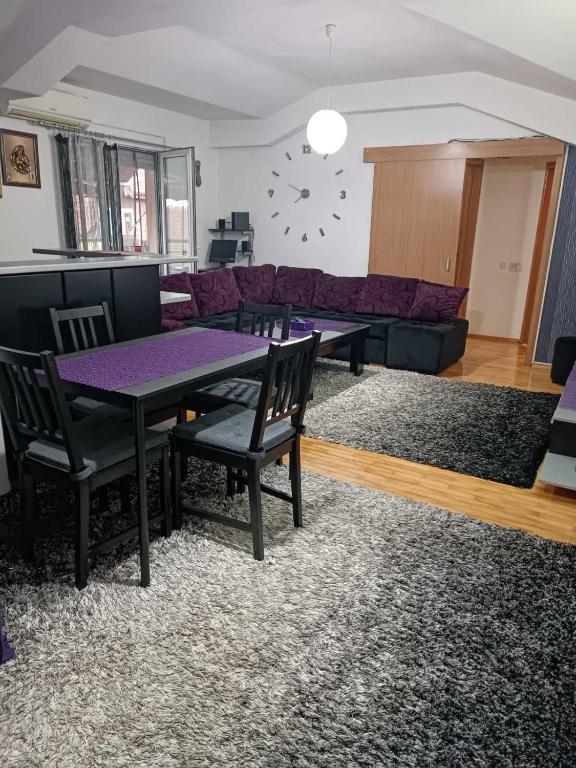 salon ze stołem i fioletową kanapą w obiekcie SKY APARTMENTS w mieście Kumanowo