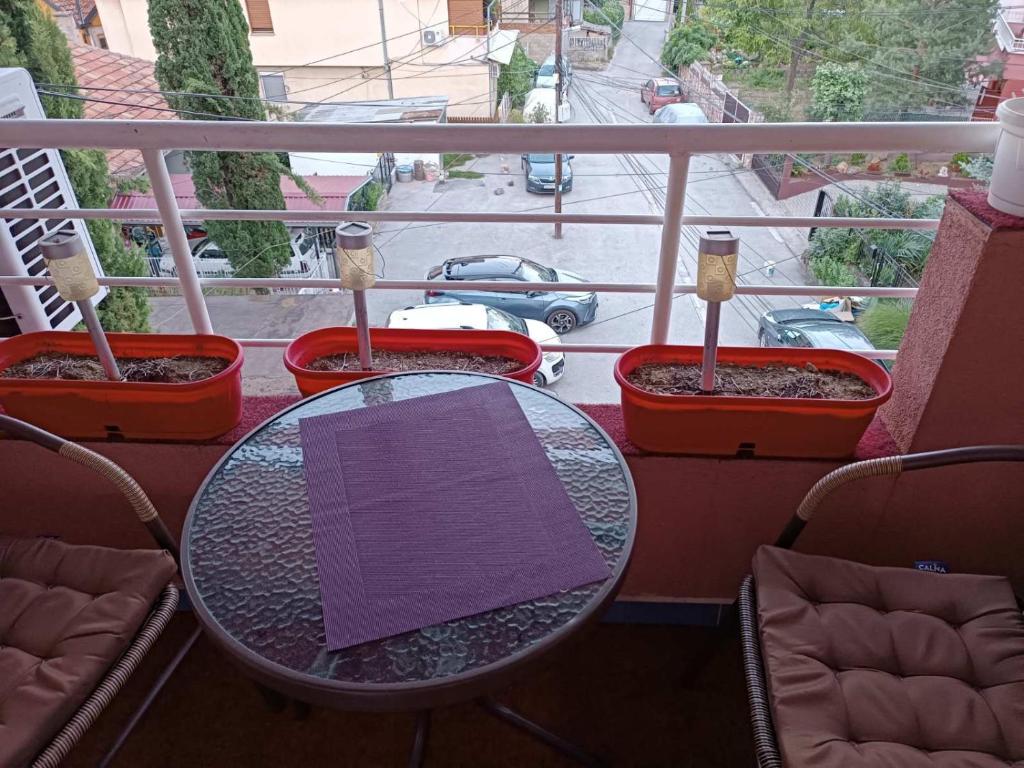 庫馬諾沃的住宿－SKY APARTMENTS，阳台顶部一张带紫色餐巾的桌子