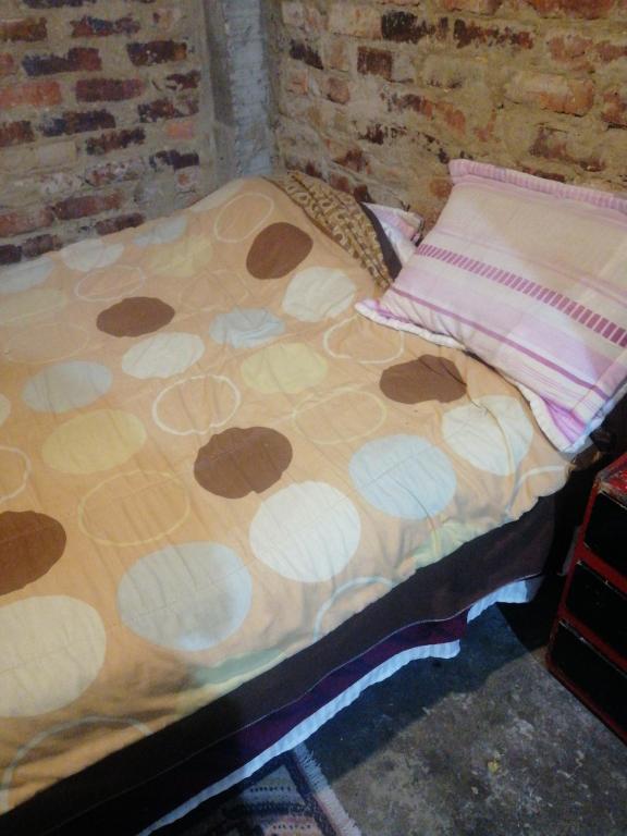 a bed with a blanket and a pillow on it at Casa familiar in El Apogeo