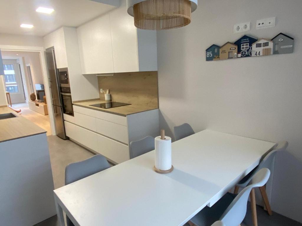 a white kitchen with a white table and chairs at Egona - SAL14 Apartamento en nueva zona residencial en Zarautz in Zarautz