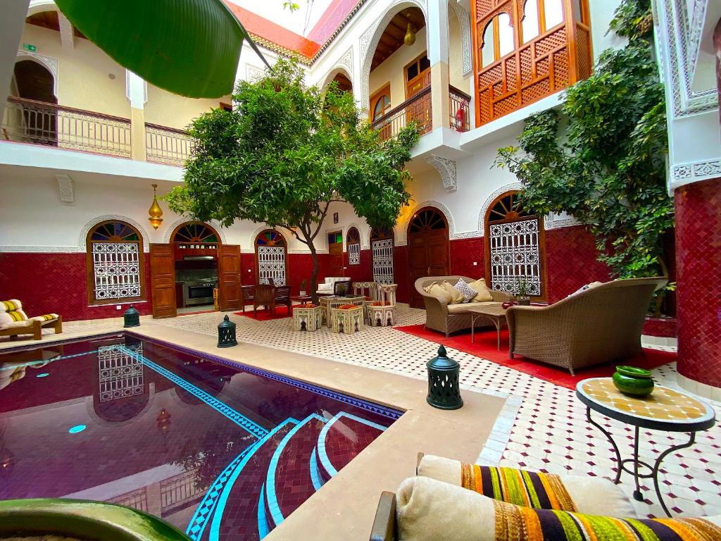 um lobby do hotel com uma piscina no meio em Riad La Perle Rouge em Marrakech