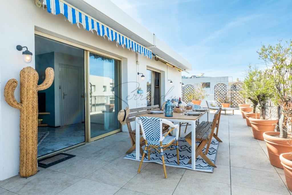 une terrasse avec une table, des chaises et un cactus dans l'établissement 2-Br Rooftop in Palm Beach 2-min walk to beaches, à Cannes