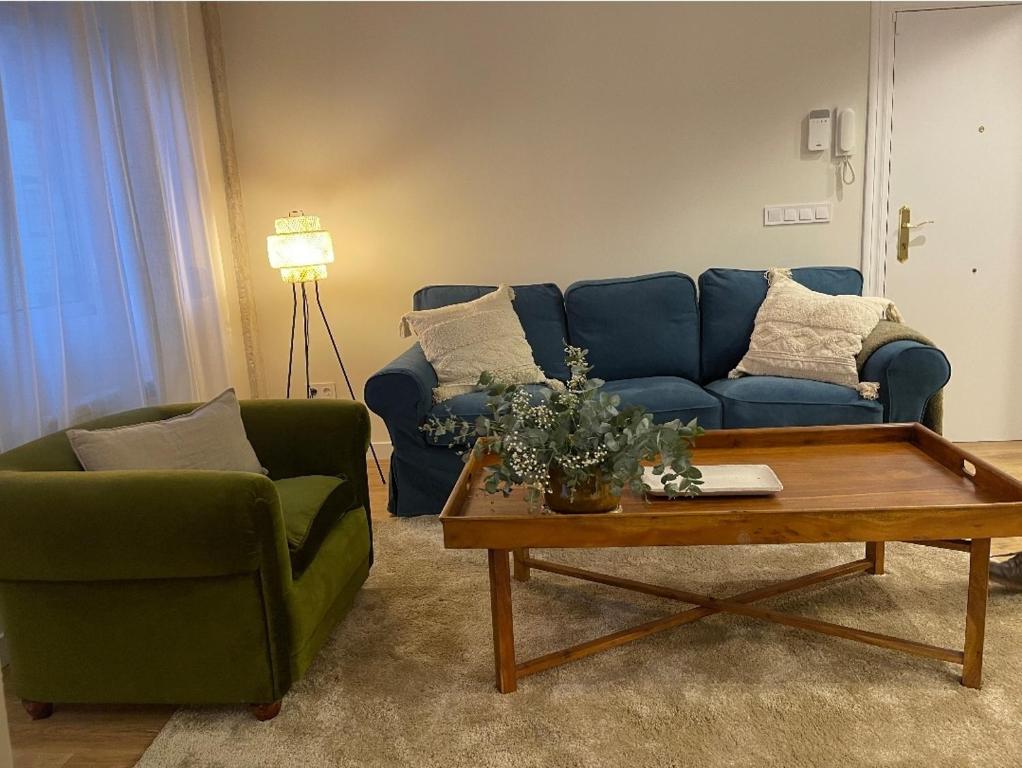 Sala de estar con sofá azul y mesa de centro en APARTAMENTO 4 PAX RECIÉN REFORMADO EN EL CENTRO DE SANTANDER, en Santander
