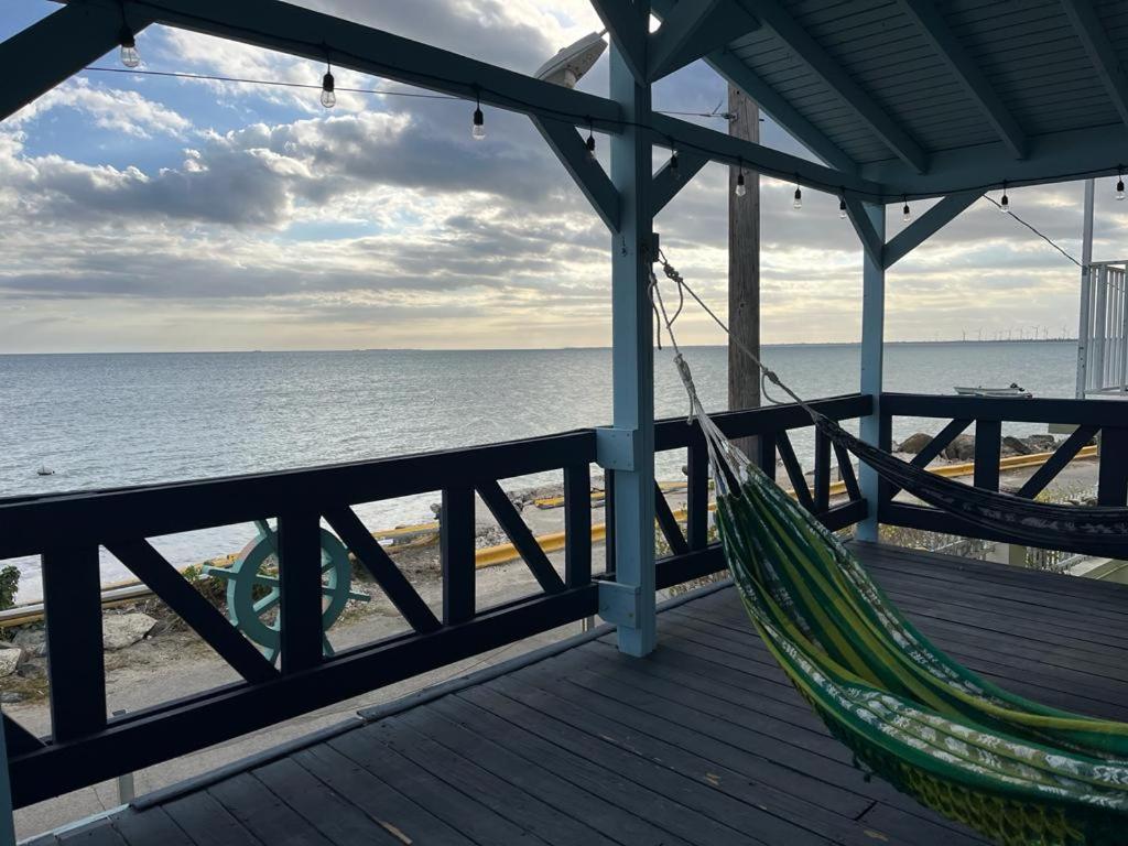 a hammock on a porch overlooking the beach at Pedazo del Mar Beach House in Salinas