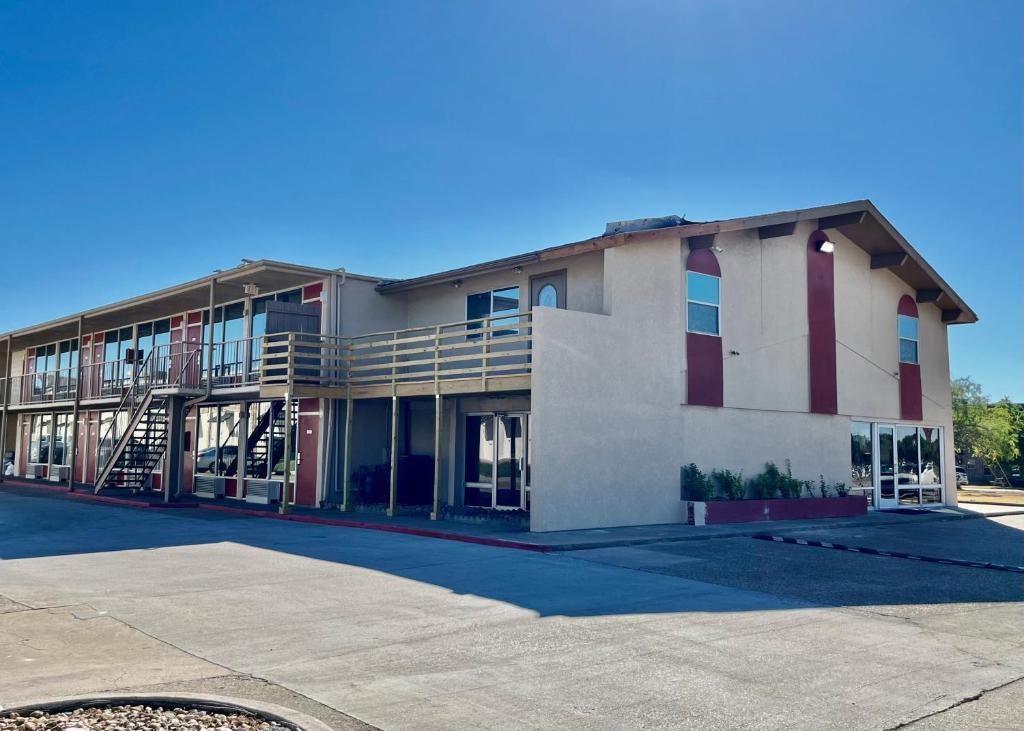 a building with a parking lot in front of it at EZ Travel Inn College Station in College Station