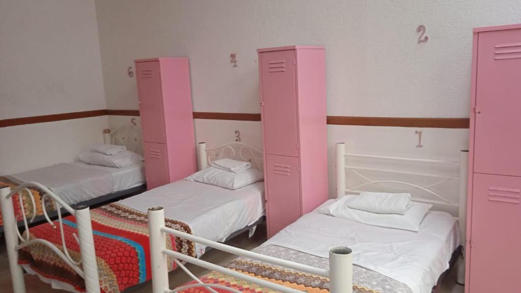 Ce dortoir comprend 2 lits superposés et des armoires roses. dans l'établissement Hostal Santo Domingo, à Puebla