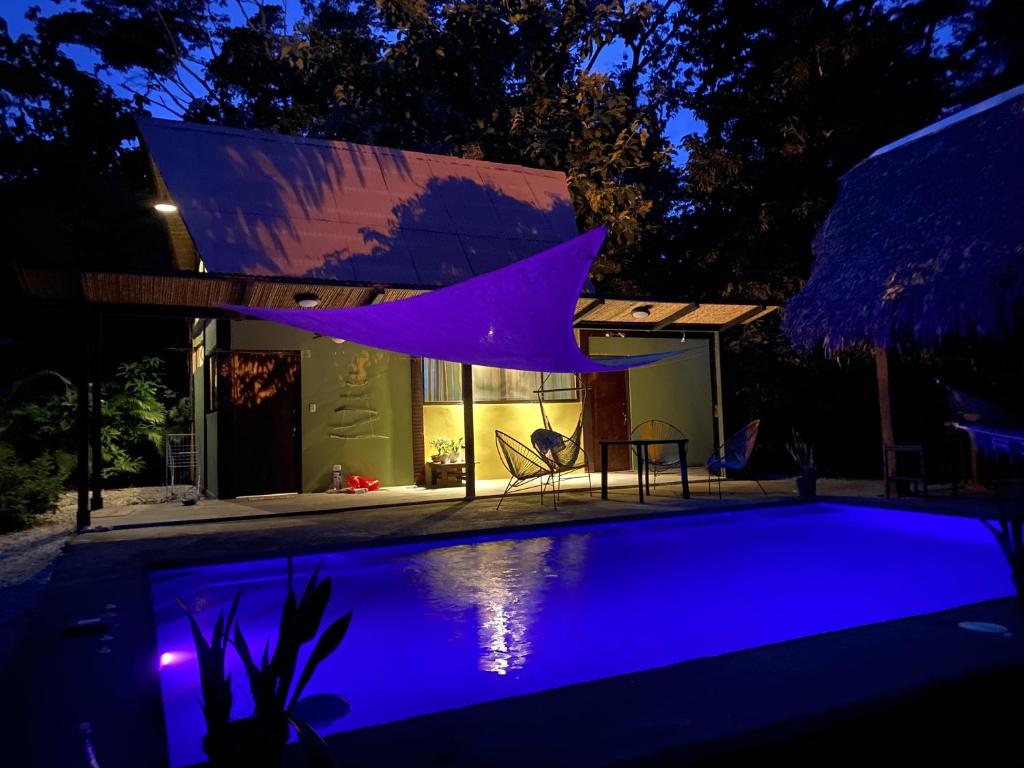 una casa con piscina por la noche en Las Plumas de Cabuya, en Cabuya