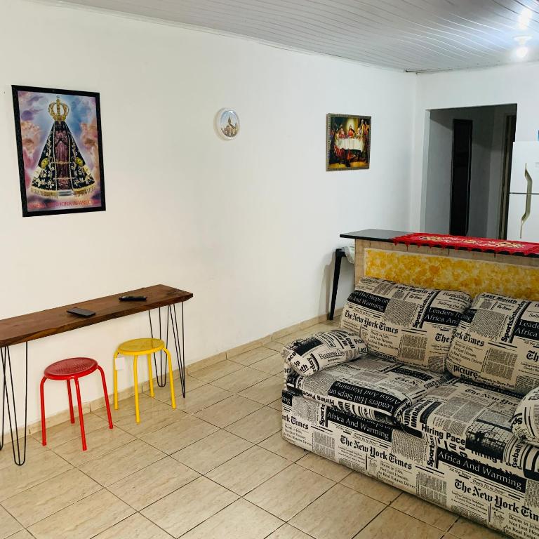 - un salon avec un canapé, une table et un tabouret dans l'établissement Mãezinha do céu, à Aparecida