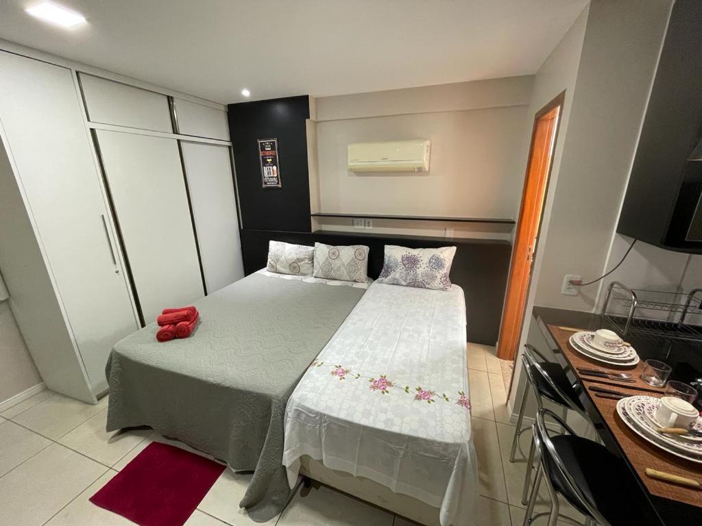 un dormitorio pequeño con una cama con un objeto rojo. en Flat Luxo Completo em Boa Viagem junto ao Shopping, en Recife