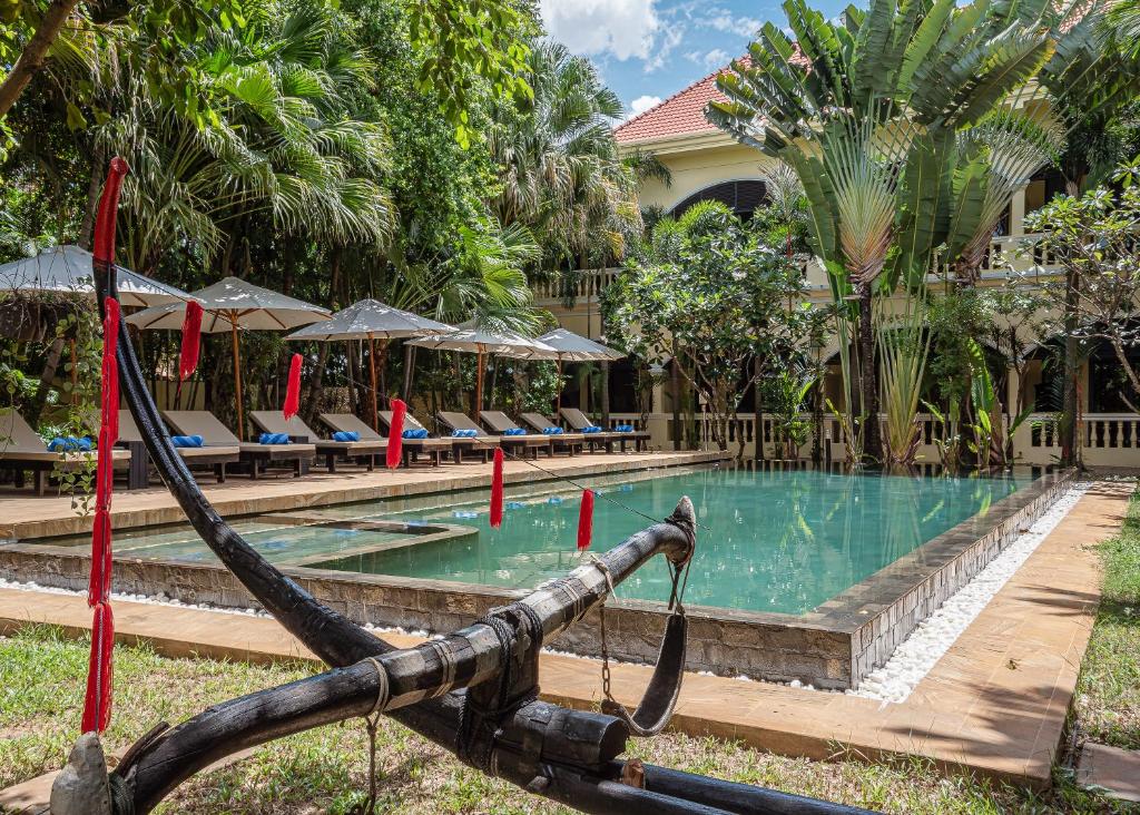uma piscina com cadeiras e um resort em Pavillon d'Orient Boutique Hotel em Siem Reap