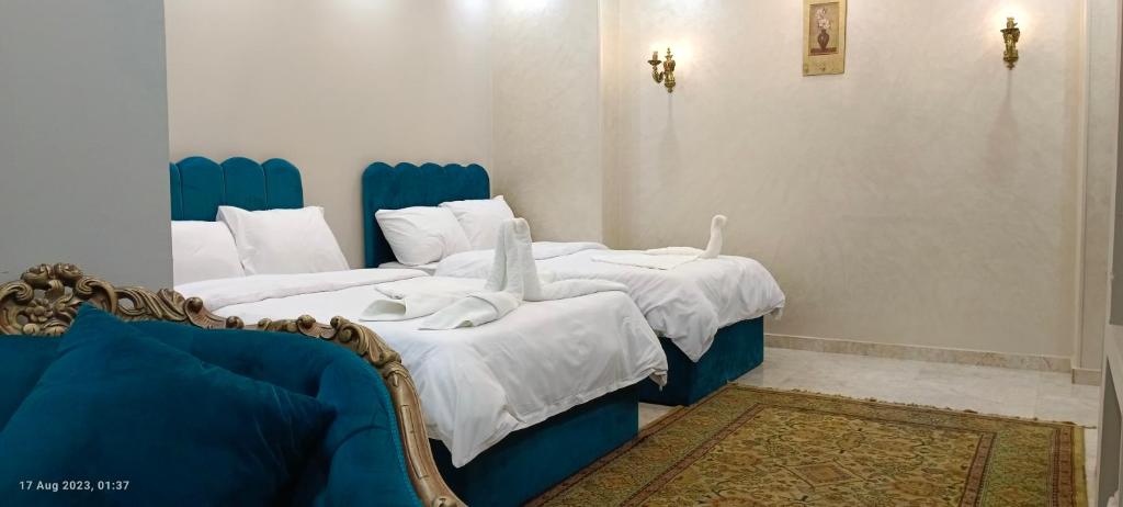 two beds in a room with blue and white at Crystal pyramid inn in Cairo
